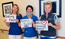 Nurses hold up signs that say safety first, nurses rock and we love oncology nursing